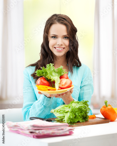 Photo: woman in the kitchen with vegetables woman in the kitchen with vegetables