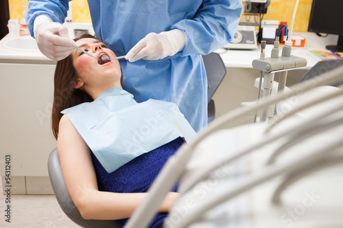 Photo: Dentist doing a dental treatment Dentist doing a dental treatment