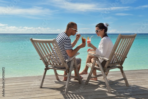 Photo: happy young couple relax and take fresh drink happy young couple relax and take fresh drink