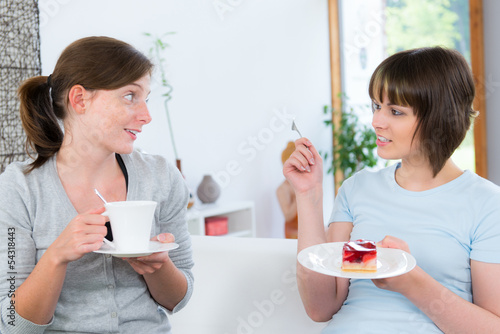 Photo: frau erzählt ihrer freundin etwas bei kuchen und kaffee frau erzählt ihrer freundin etwas bei kuchen und kaffee