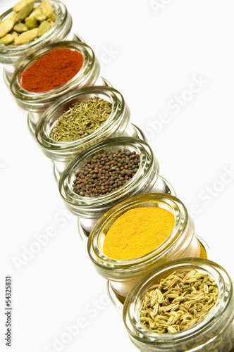 Photo: Herbs and spices in glass jars, isolated on white background Herbs and spices in glass jars, isolated on white background