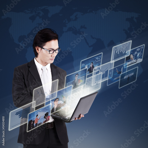 Photo: Businessman choosing online pictures on laptop Businessman choosing online pictures on laptop