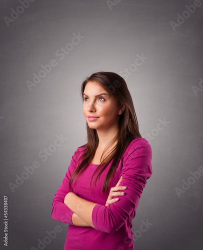 Photo: Young woman standing and thinking with copy space Young woman standing and thinking with copy space