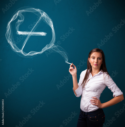 Photo: Young lady smoking unhealthy cigarette with no smoking sign Young lady smoking unhealthy cigarette with no smoking sign