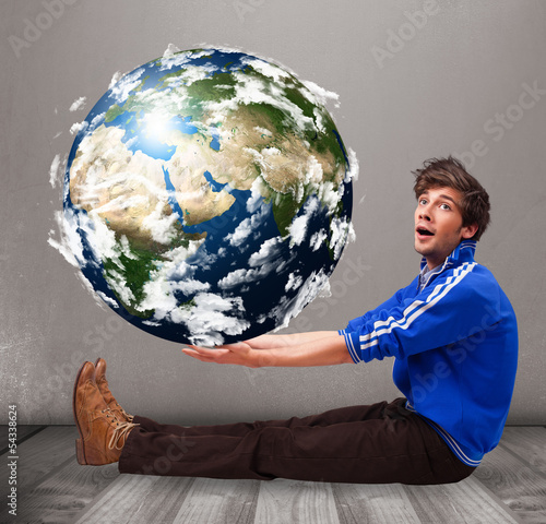 Photo: Good-looking man holding 3d planet earth Good-looking man holding 3d planet earth