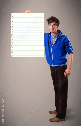 Photo: Young man holding white paper copy space with diagonal lines Young man holding white paper copy space with diagonal lines