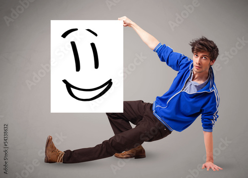 Photo: Young boy holding smiley face drawing Young boy holding smiley face drawing