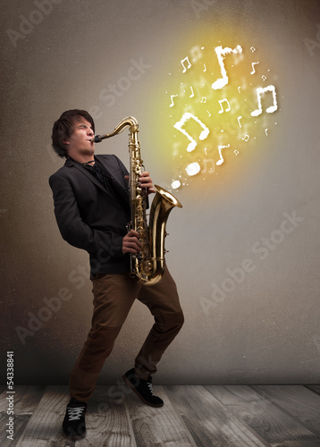 Photo: Handsome musician playing on saxophone with musical notes Handsome musician playing on saxophone with musical notes