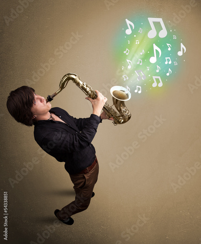Photo: Young musician playing on saxophone while musical notes explodin Young musician playing on saxophone while musical notes explodin