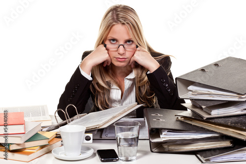 Photo: stressed woman in front of a desk stressed woman in front of a desk