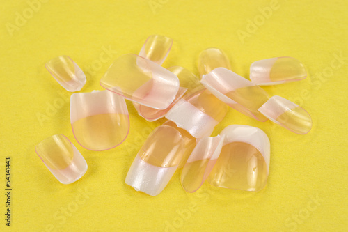 Photo: False fingernails on yellow background False fingernails on yellow background