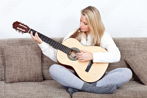 Photo: young woman practises playing the guitar young woman practises playing the guitar