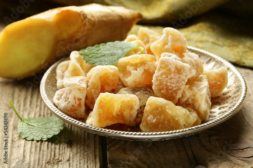 Photo: sugared ginger (candied) and fresh root on a wooden table sugared ginger (candied) and fresh root on a wooden table