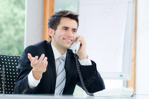 Photo: freundlicher geschäftsmann beim telefonieren freundlicher geschäftsmann beim telefonieren