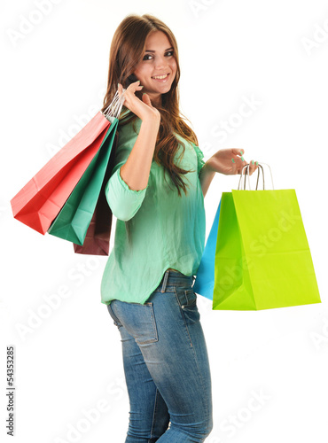 Photo: Young happy woman with colorful paper shopping bags isolated Young happy woman with colorful paper shopping bags isolated