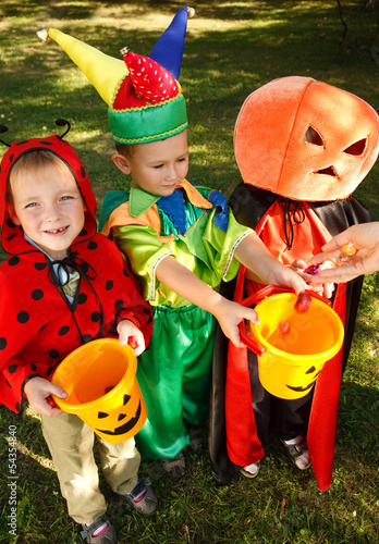 Photo: Three boys in Halloween costumes are getting their candies Three boys in Halloween costumes are getting their candies