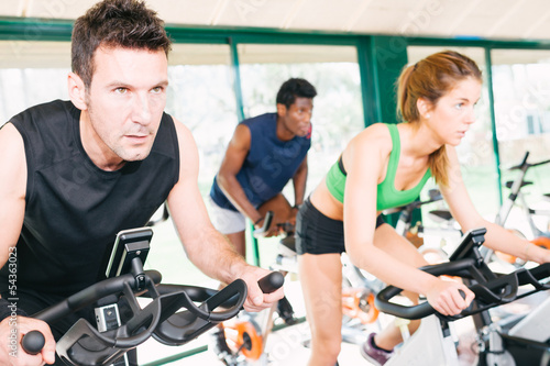 Photo: Three Friends Are In A Spinning Class At Gym Three Friends Are In A Spinning Class At Gym