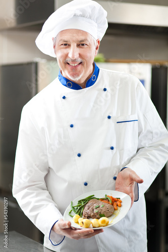 Photo: Chef holding a dish Chef holding a dish