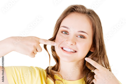 Photo: Teen girl pointing on her perfect teeth Teen girl pointing on her perfect teeth