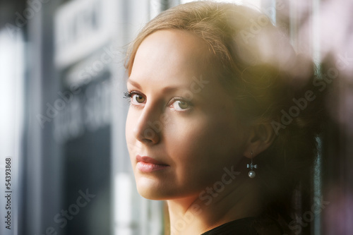 Photo: Sad beautiful woman looking out window Sad beautiful woman looking out window