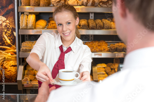 Photo: Saleswoman in baker's shop giving cup of coffee to customer Saleswoman in baker's shop giving cup of coffee to customer
