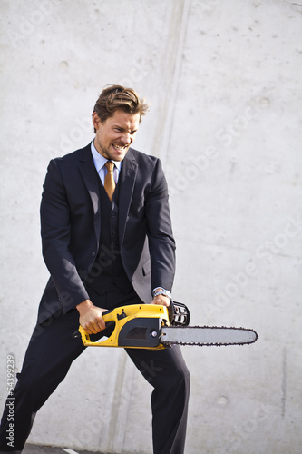 Photo: Crazy businessman with a chainsaw Crazy businessman with a chainsaw