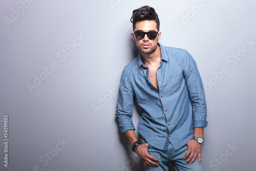 Photo: casual man poses with thumbs in pockets on gray casual man poses with thumbs in pockets on gray
