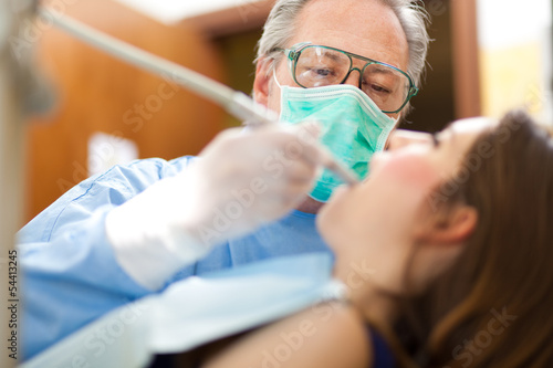 Photo: Dentist doing a treatment Dentist doing a treatment
