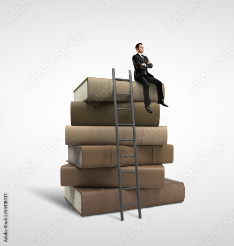 Photo: businessman sitting on books businessman sitting on books