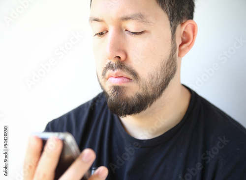 Photo: man looking down at his smartphone man looking down at his smartphone