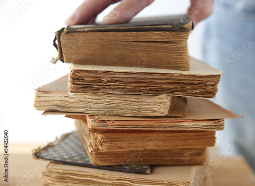 Photo: hand of a man on old books hand of a man on old books