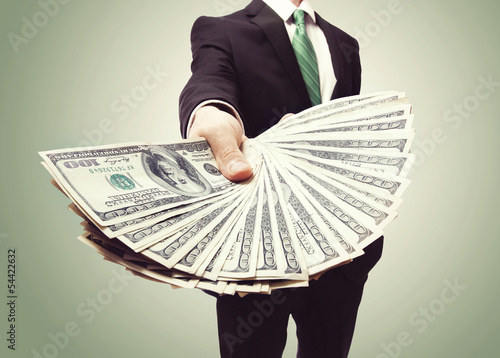 Photo: Business Man Displaying a Spread of Cash Business Man Displaying a Spread of Cash