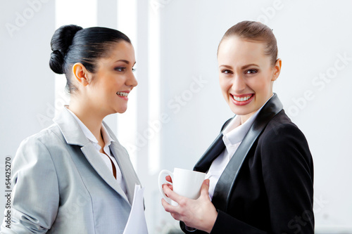 Photo: Two attractive business women smiling Two attractive business women smiling