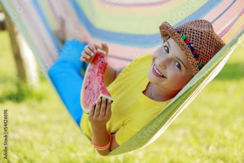 Photo: Summer joy - happy girl with watermelon in hammock Summer joy - happy girl with watermelon in hammock