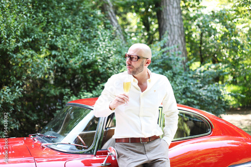 Photo: Mann mit Champagner und Sportwagen Mann mit Champagner und Sportwagen