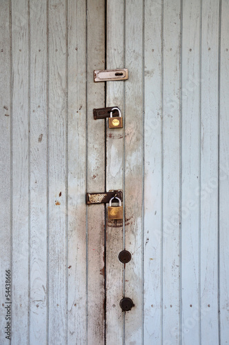 Photo: White grunge plywood classic door with padlocks. White grunge plywood classic door with padlocks.