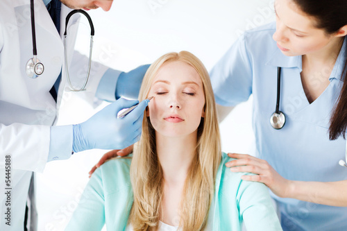 Photo: plastic surgeon and nurse with patient plastic surgeon and nurse with patient