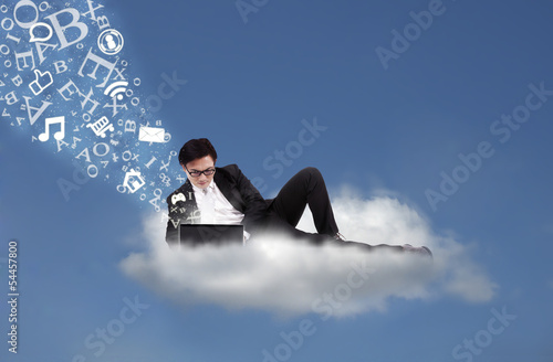 Photo: Asian businessman working on cloud with flying alphabet Asian businessman working on cloud with flying alphabet