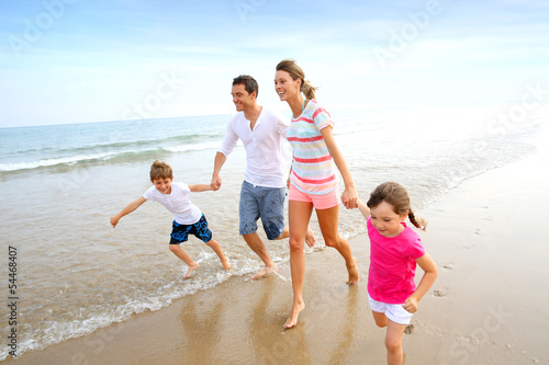 Photo: Happy family running on the beach Happy family running on the beach