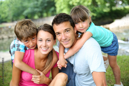 Photo: Family relaxing by river in countryside Family relaxing by river in countryside