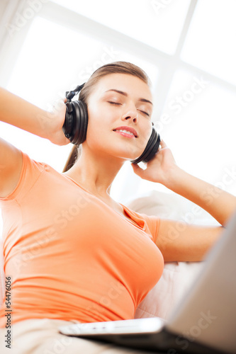 Photo: woman with headphones and laptop at home woman with headphones and laptop at home