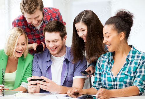 Photo: students looking at smartphone at school students looking at smartphone at school