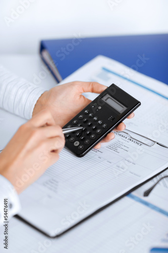 Photo: woman hand with calculator and papers woman hand with calculator and papers