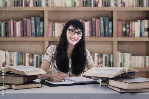 Photo: Beautiful female student study at library Beautiful female student study at library
