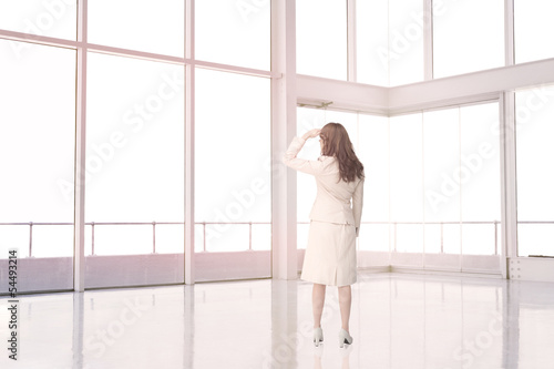 Photo: Businesswoman standing in an empty room Businesswoman standing in an empty room