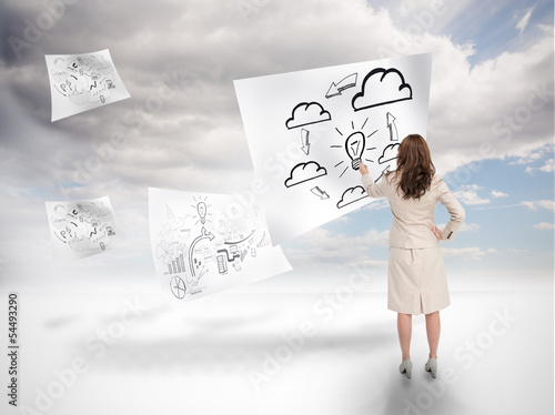 Photo: Businesswoman drawing on a floating paper Businesswoman drawing on a floating paper
