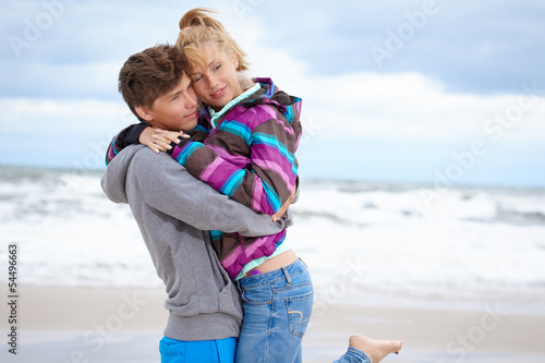 Photo: happy pair of male and female embracing and having fun wearing w happy pair of male and female embracing and having fun wearing w