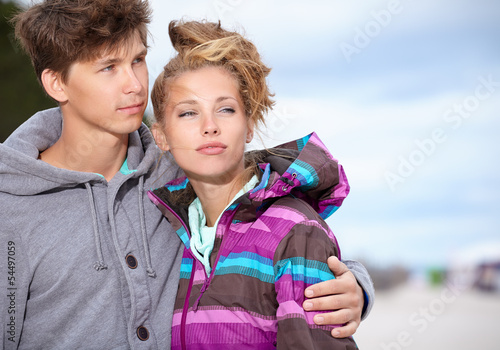 Photo: Couple embracing and having fun wearing warm clothes outside on Couple embracing and having fun wearing warm clothes outside on
