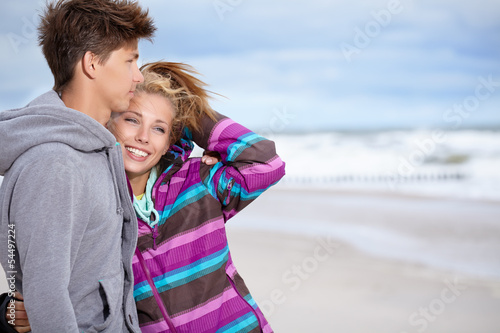 Photo: Couple embracing and having fun wearing warm clothes outside on Couple embracing and having fun wearing warm clothes outside on