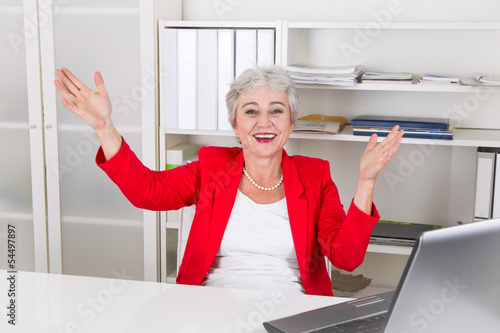 Photo: Seniorchefin - Frau mit grauen Haaren freut sich im Büro Seniorchefin - Frau mit grauen Haaren freut sich im Büro